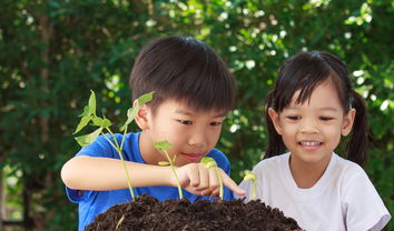 Two children outside, looking at the stages of plants growing